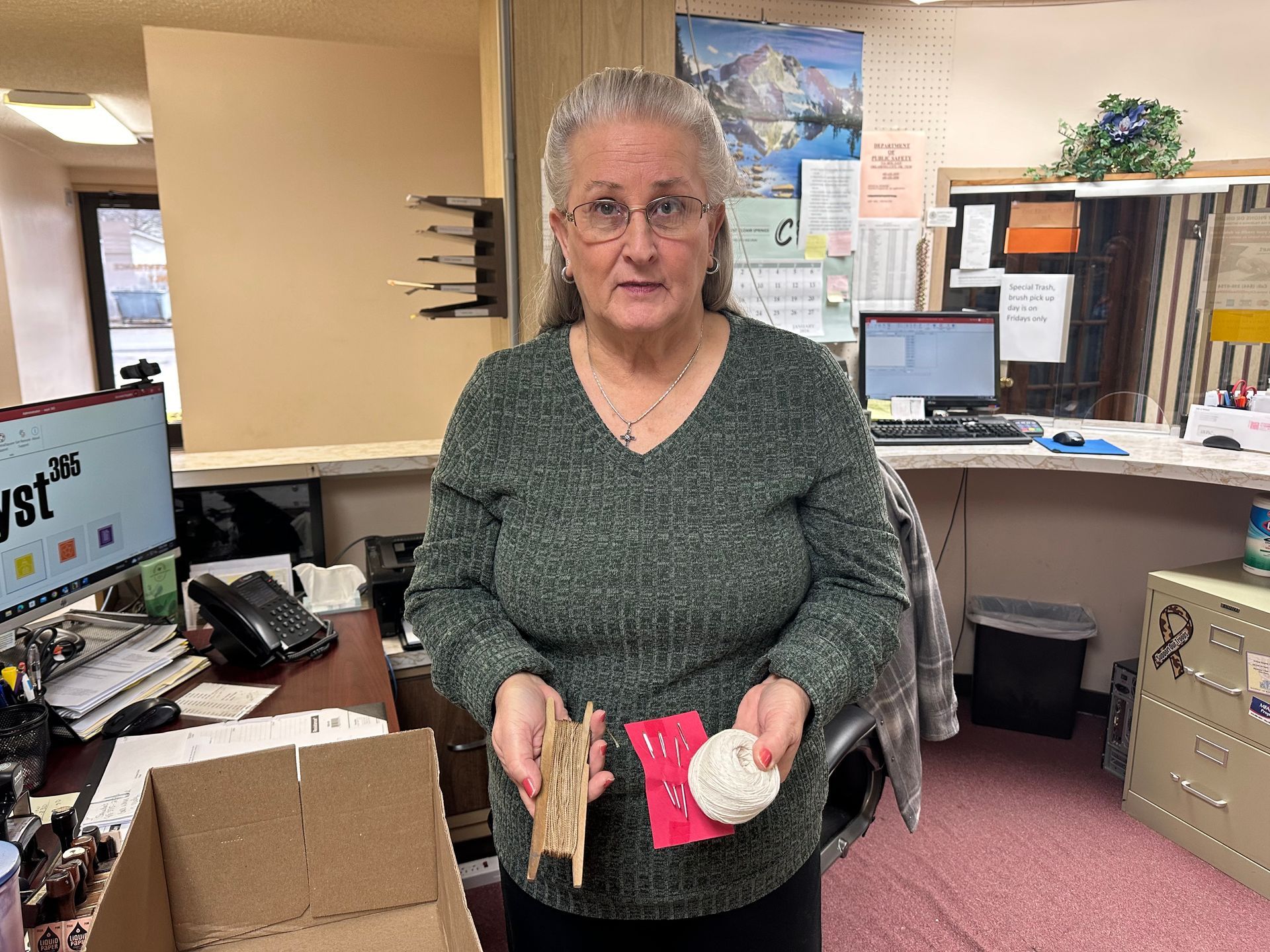 City of Stilwell staff Denise Brown displays cord and large needles that were used in past elections.