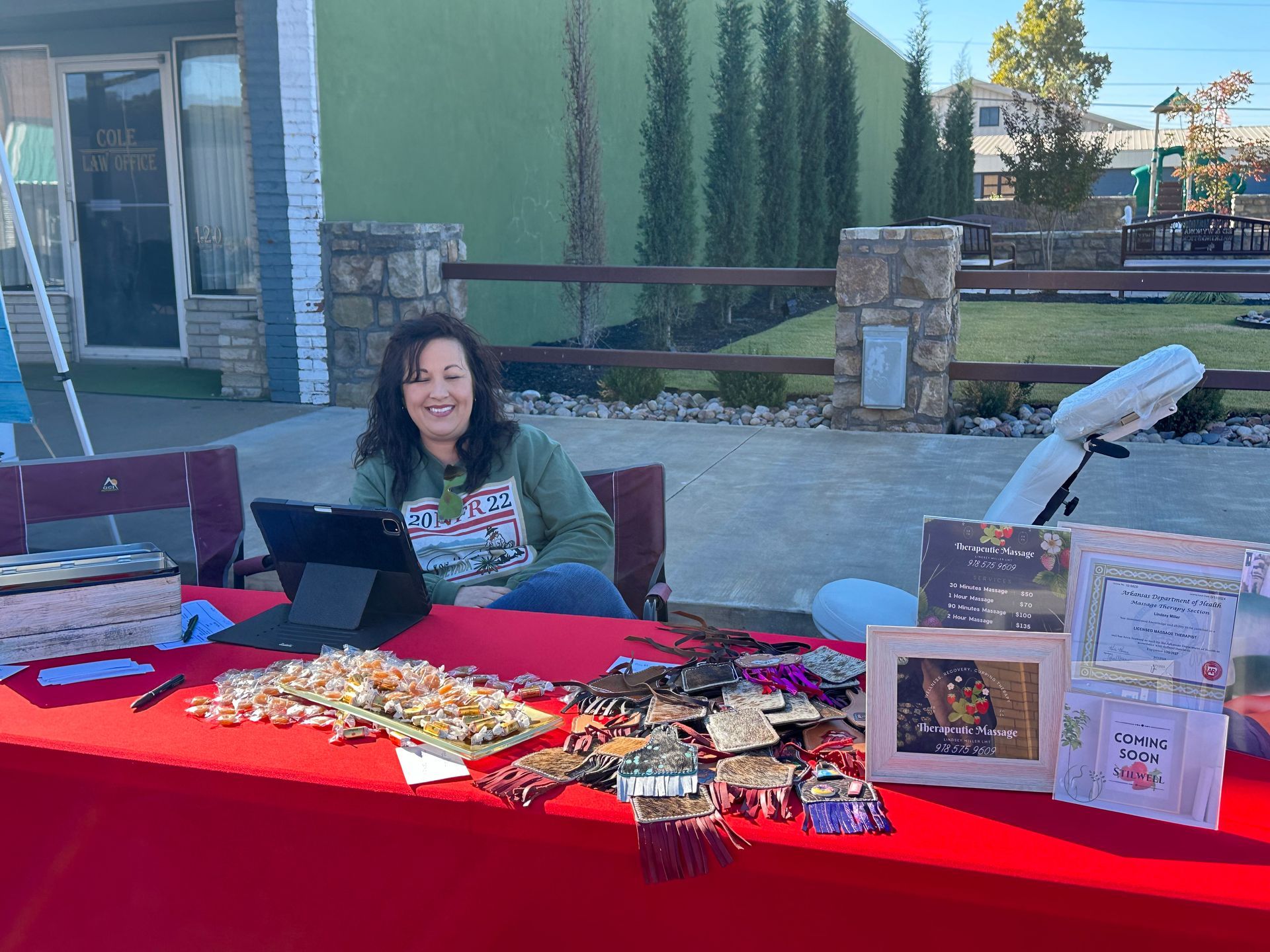 A woman is sitting at a table with a tablet.