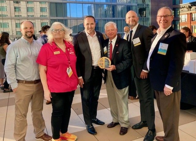 A group of people standing next to each other holding a plaque.
