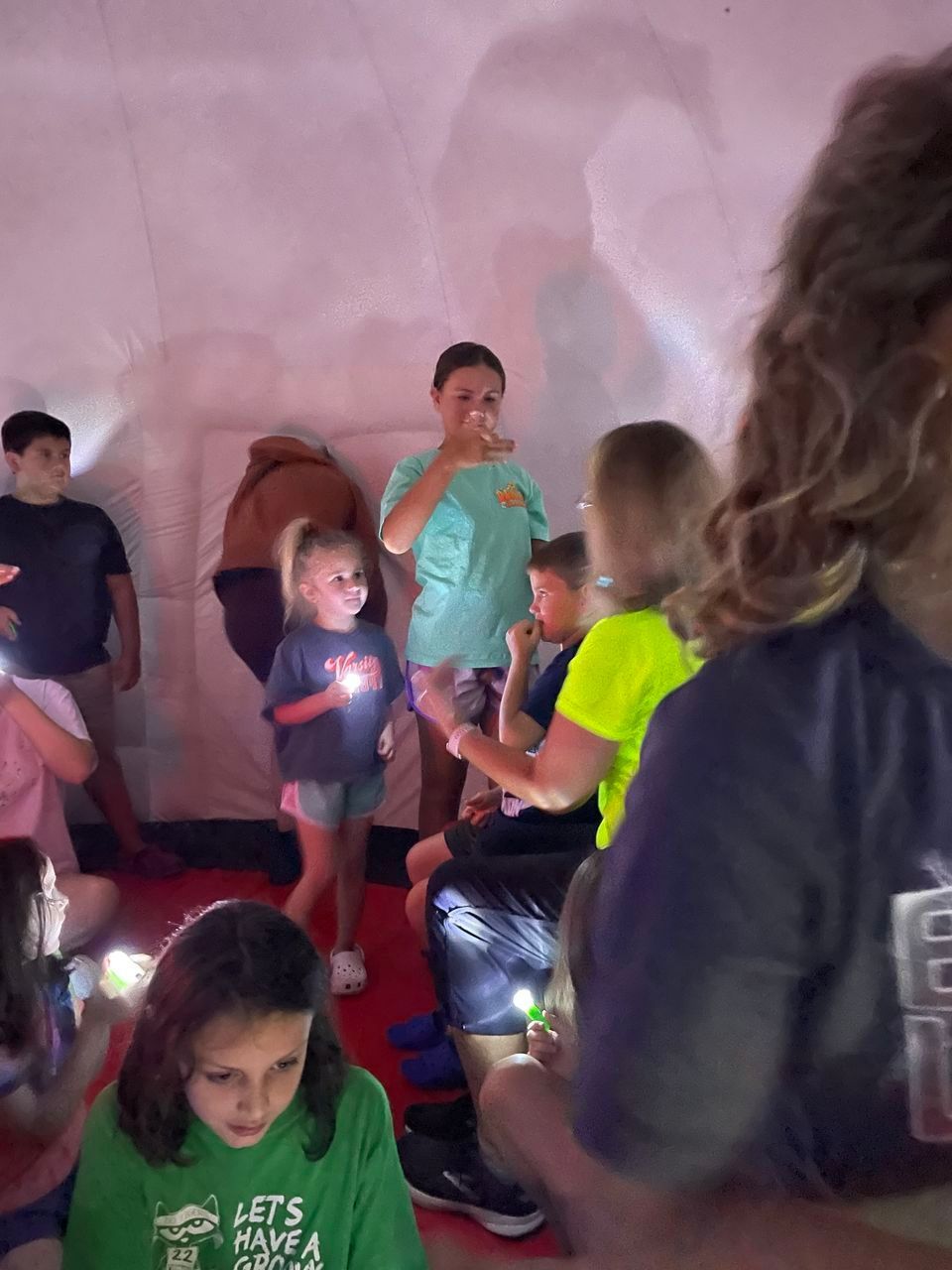 A girl in a green shirt that says let 's have a party