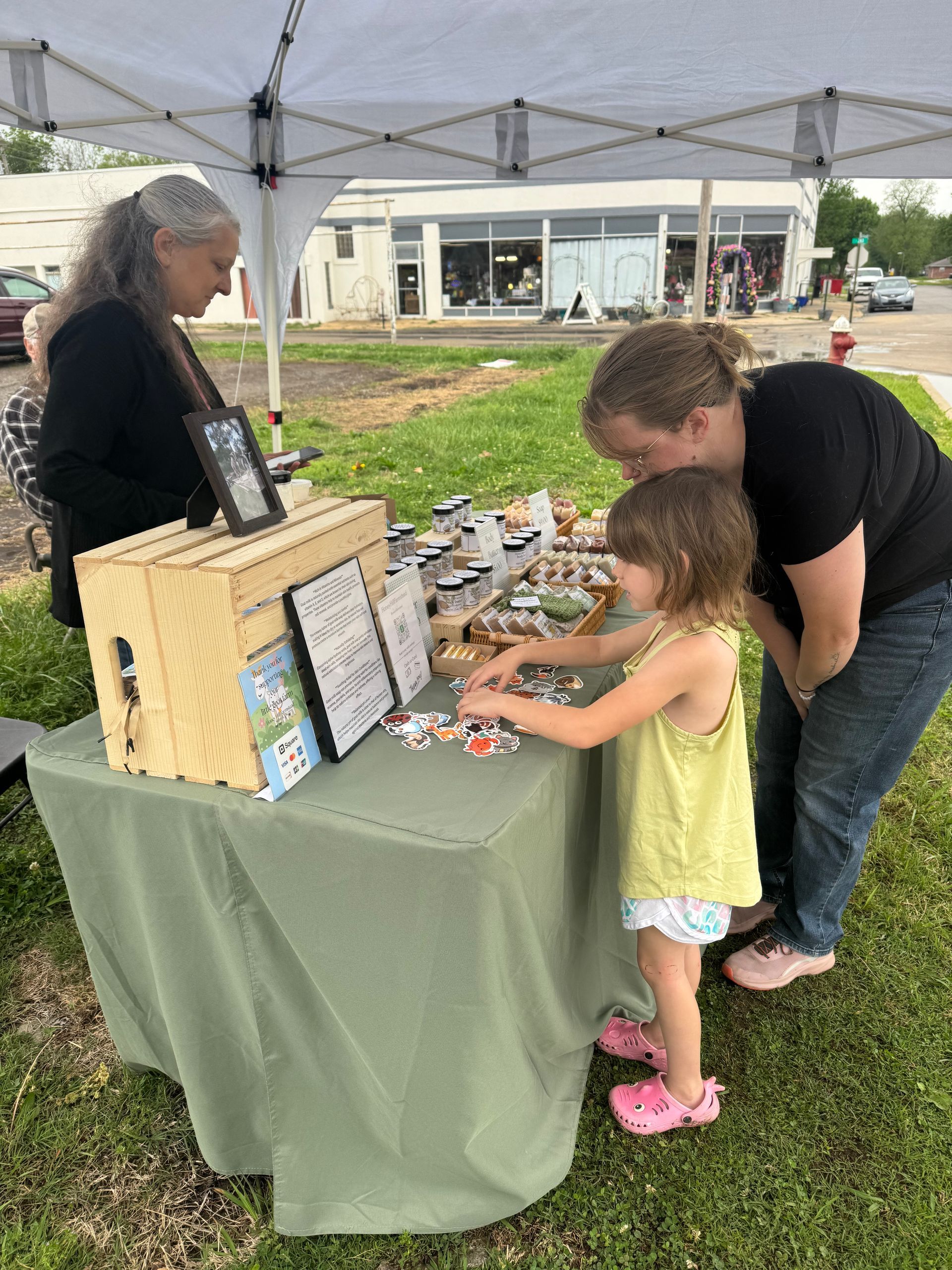 Jennifer Reynolds answers questions about her goat milk products for Abigail Whitney and daughter Alice.