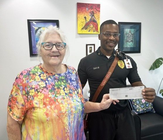 Mayor Wright presents a check from Kiwanis to Fire Department Chief Ken Hill.