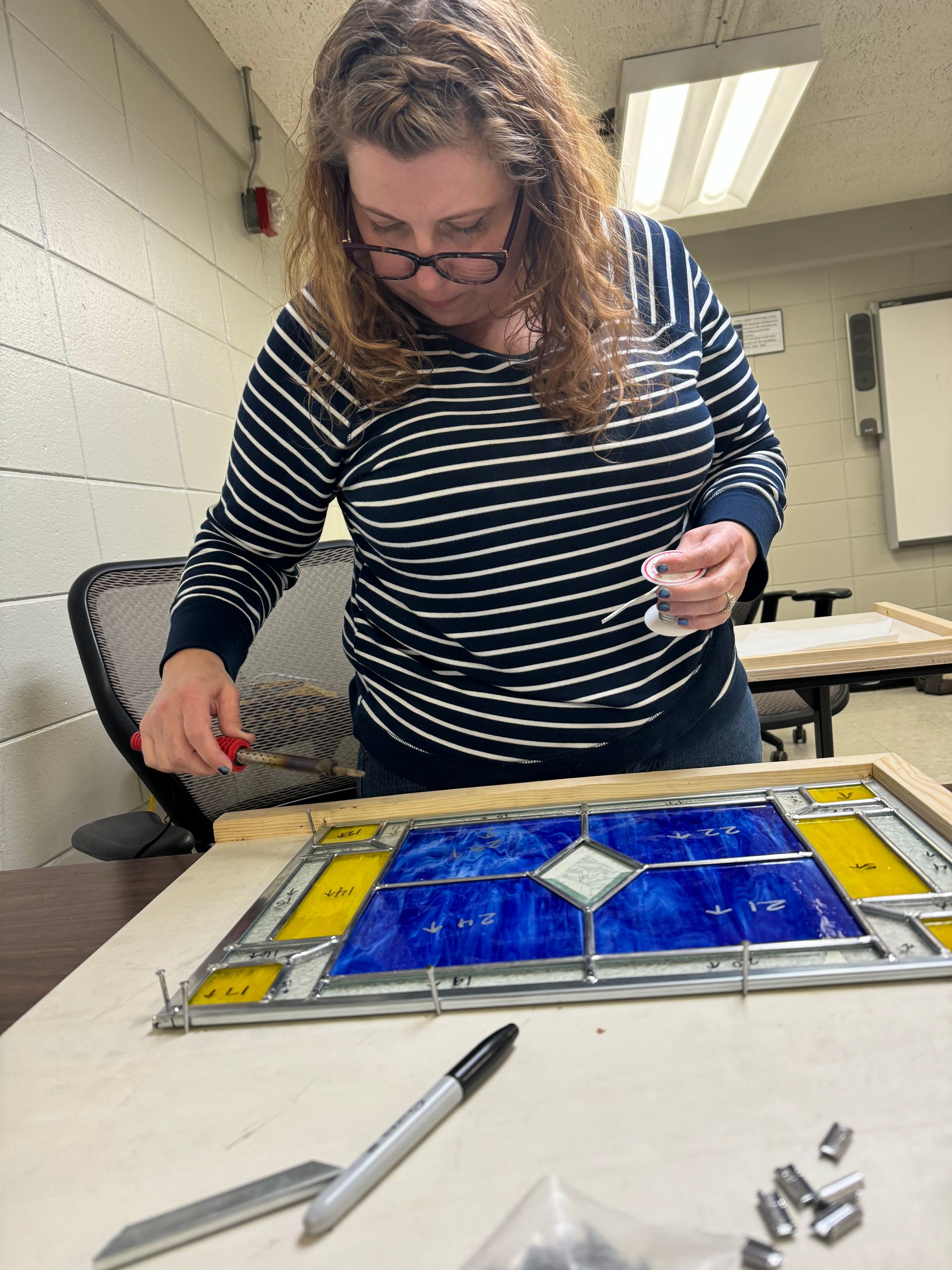 Mel Wofford soldering her piece together. 