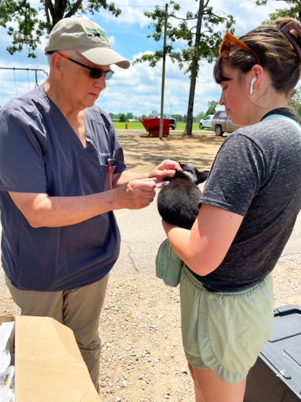 Dr. Tim Synar immunizes a puppy from the Stilwell Animal Shelter at the Stilwellness Animal Clinic. The puppy, which was also adopted, is held by volunteer Kaylee Stewart.