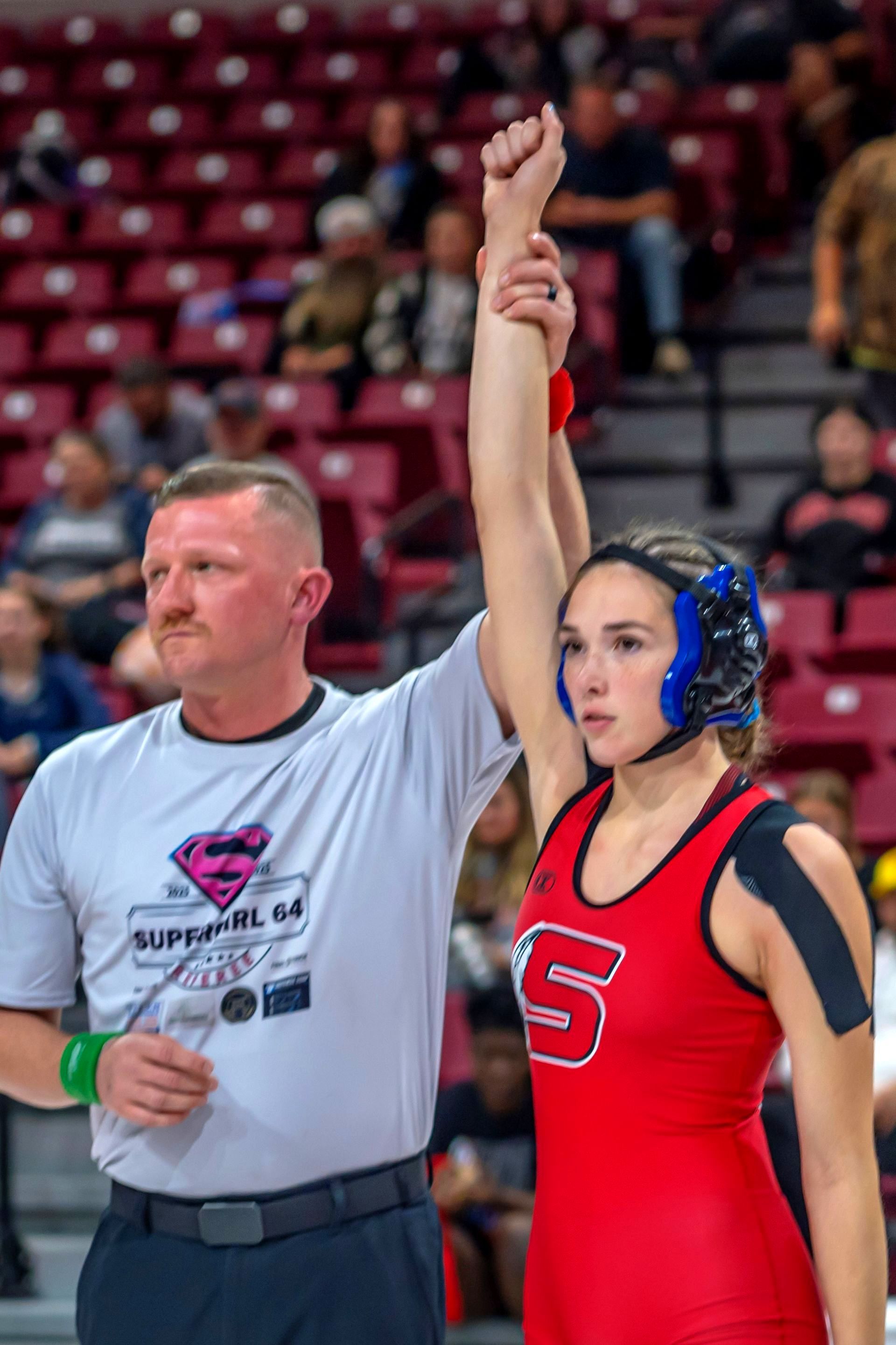 Wrestler Adrianna Chronister being declared the winner by a judge.