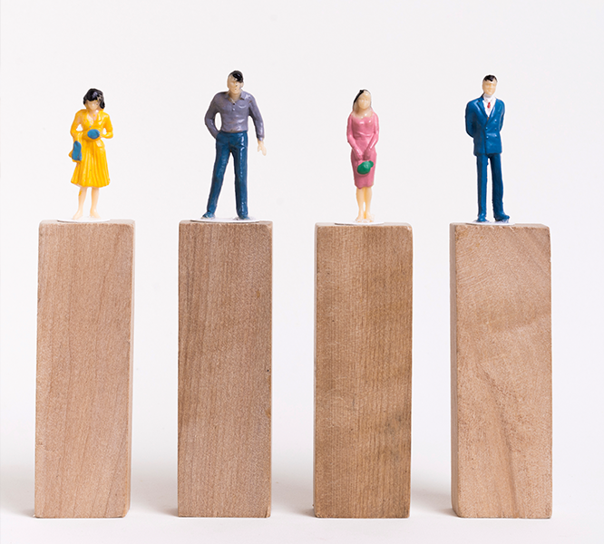 Human Figurines Standing on Wooden Plank