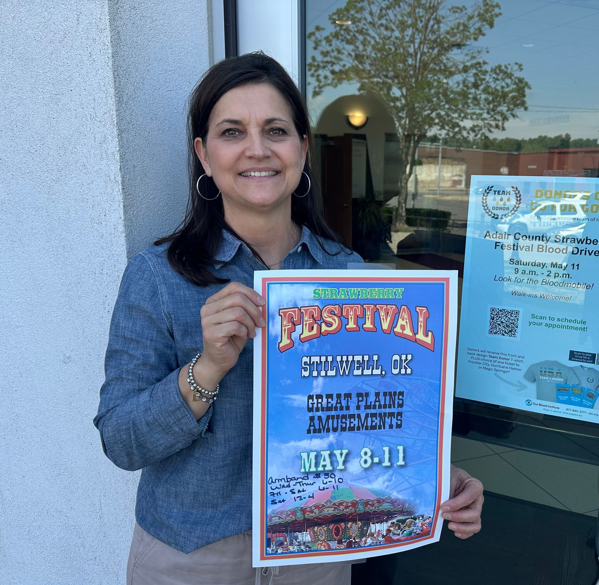 Kiwanis volunteer Liz Brown hanging fliers for the Strawberry Festival and blood drive.