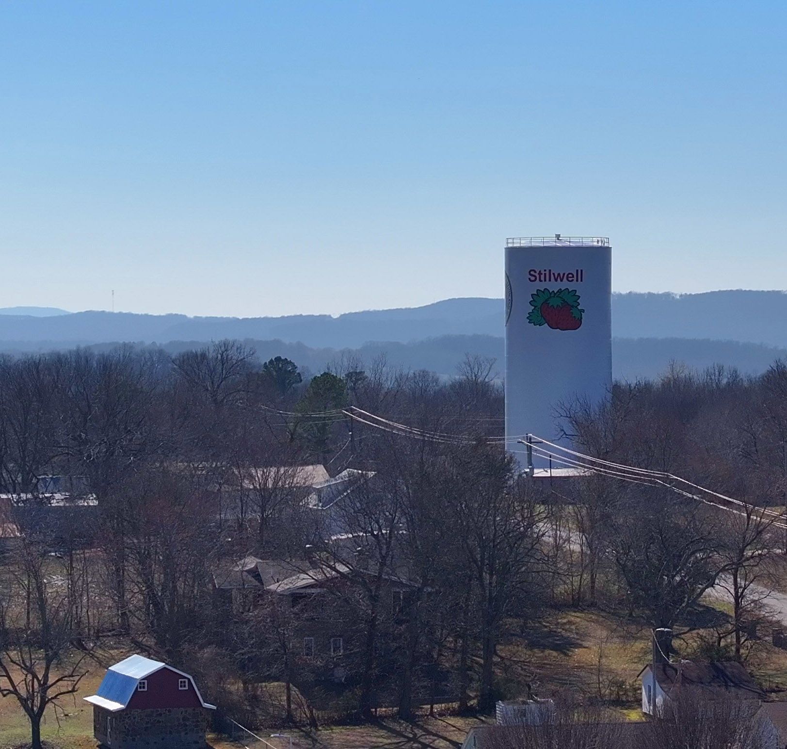 Aerial photo of Stilwell water tower, homes and hills beyond