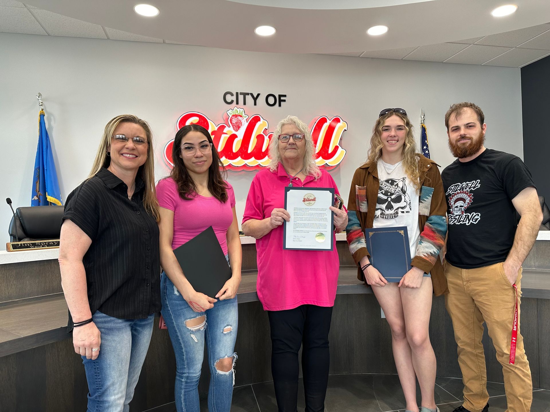 photo of Mayor Jean Ann Wright presenting a citation to girl wrestlers and coaches.