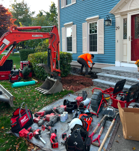 A blue pipe is laying in the dirt next to a rock