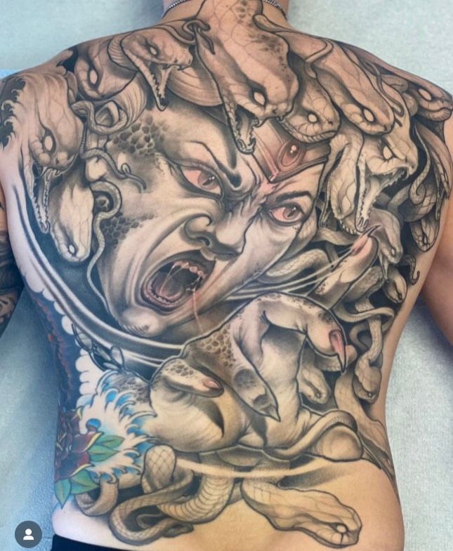 a man has a medusa tattoo on his back