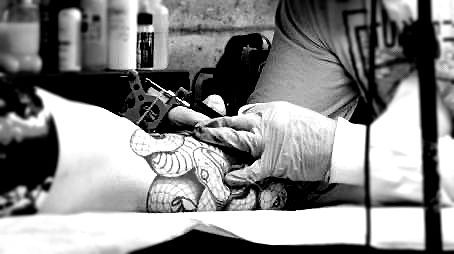 a man and a woman with tattoos on their backs are standing next to each other