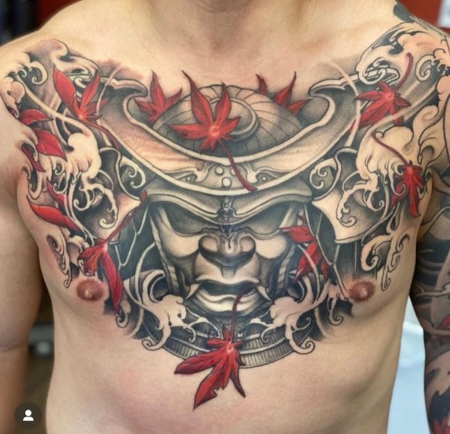 a man has a tattoo of a samurai helmet on his chest