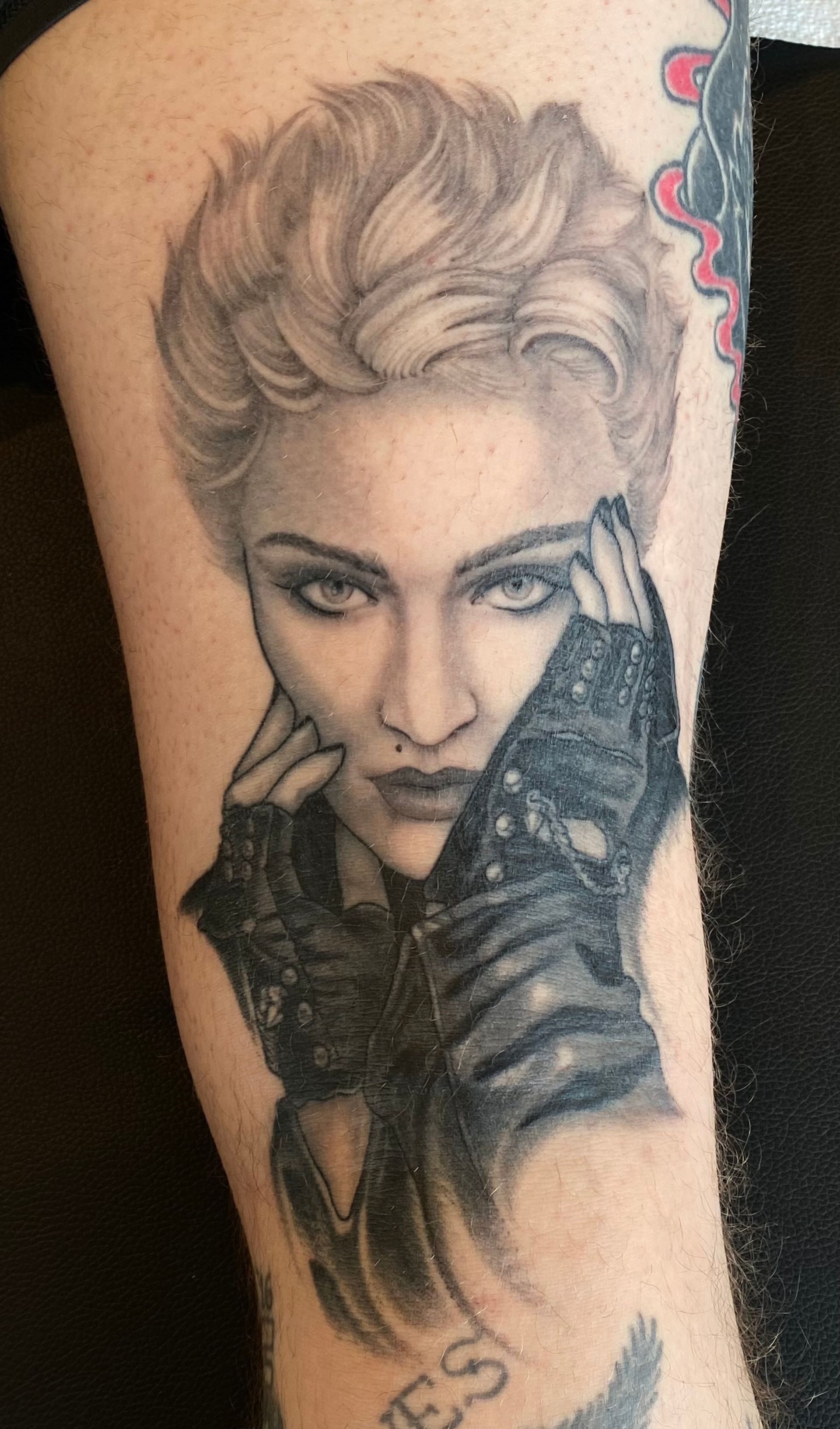 a woman has a tattoo of madonna on her leg
