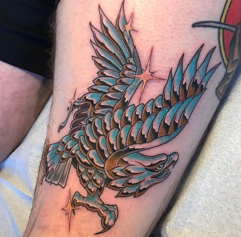 a man has a tattoo of an eagle on his leg