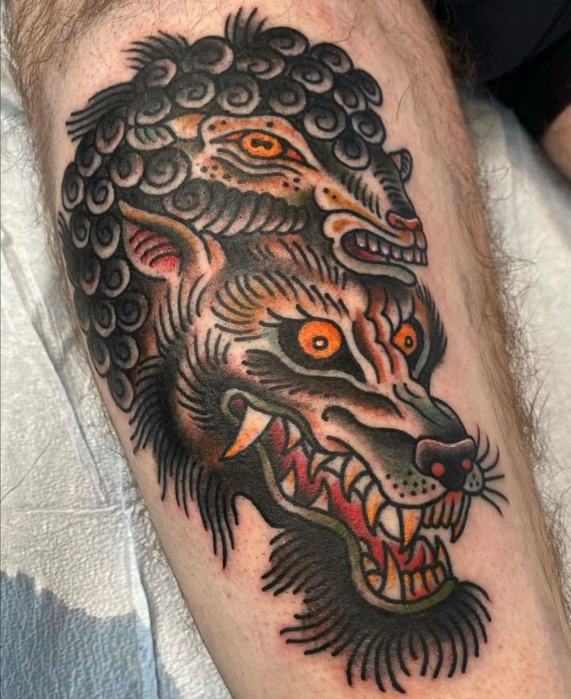 a tattoo of a wolf's head on a person's leg