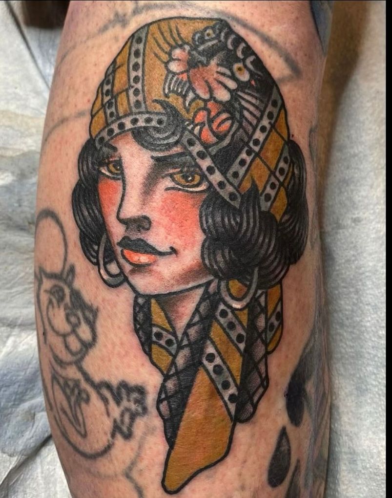 a tattoo of a woman with a scarf around her head