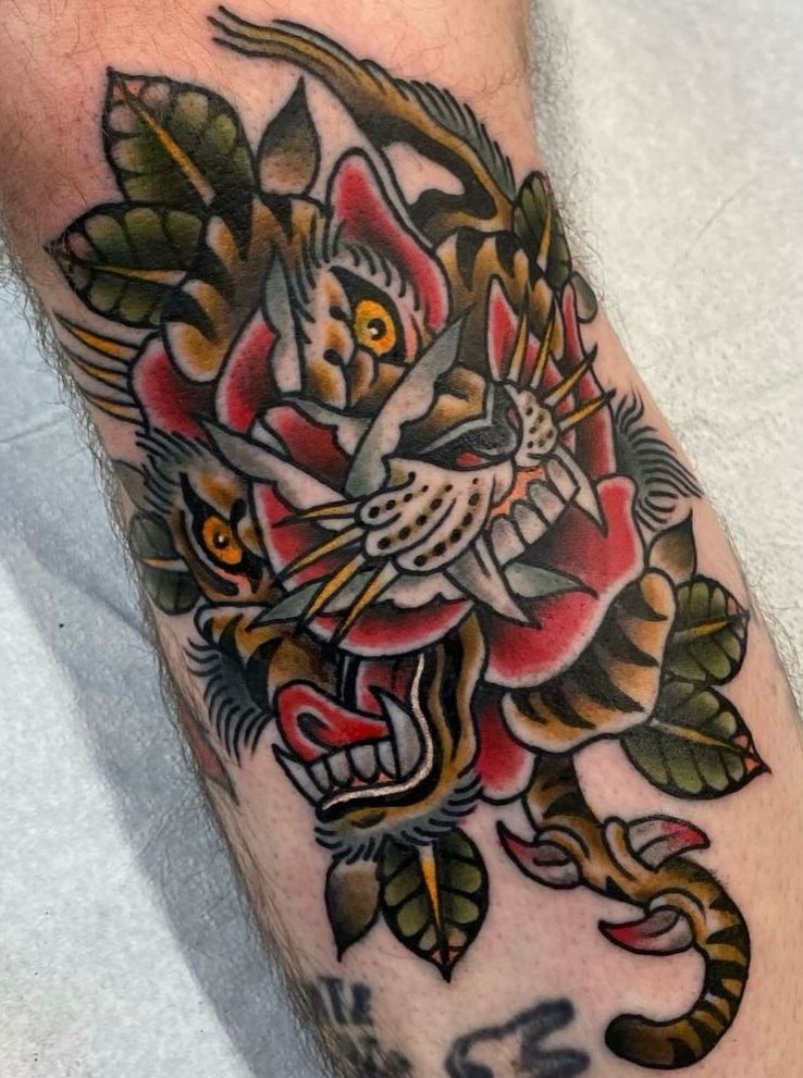 a tattoo of a tiger and a rose on a person's arm