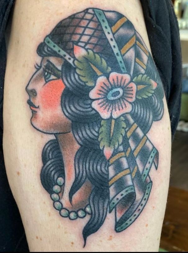 a tattoo of a woman with a flower in her hair