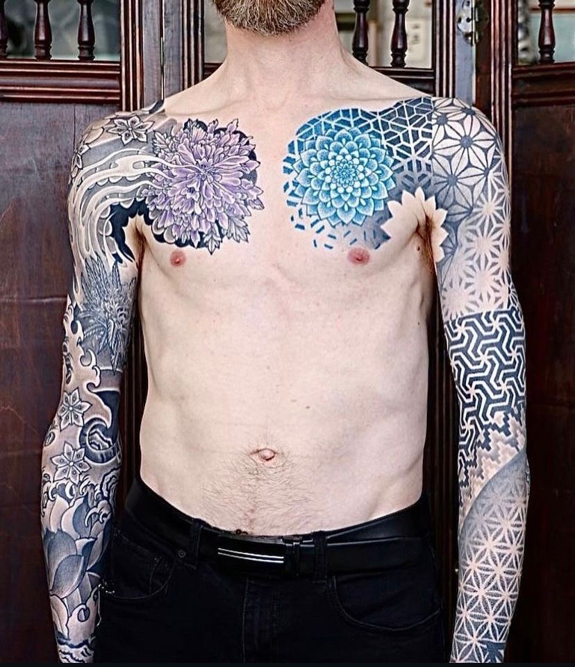 a man with a lot of tattoos on his chest and arms