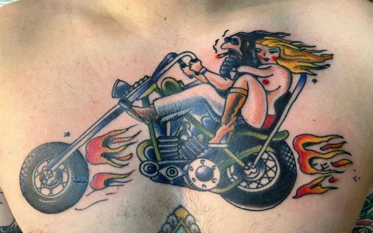 a man has a tattoo of a woman on a motorcycle