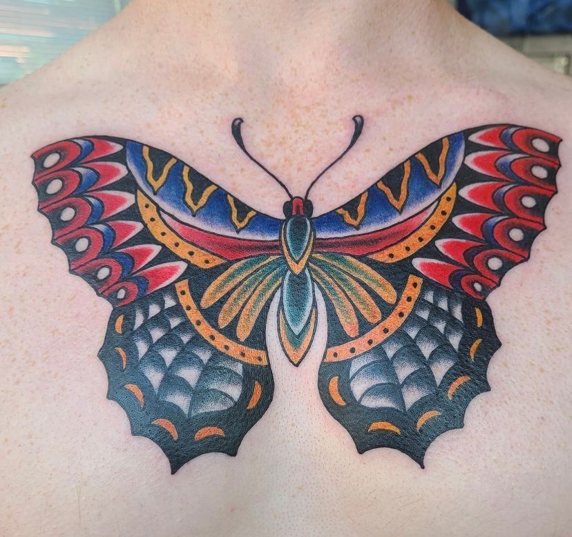 a man has a colorful butterfly tattoo on his chest