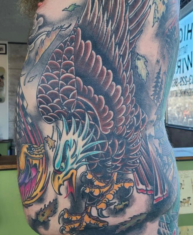 a man has a tattoo of an eagle on his side