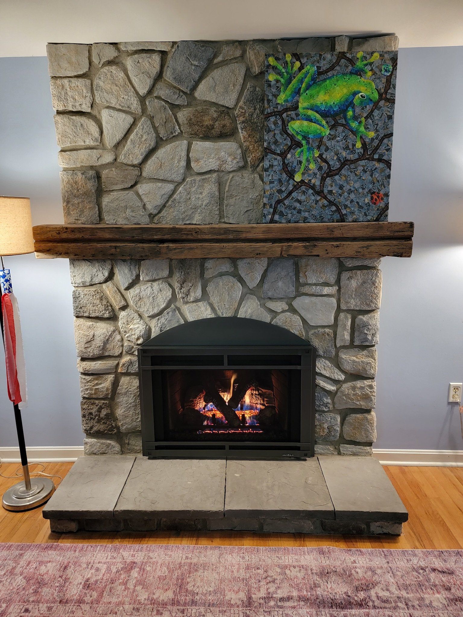 A living room with a fireplace and a lamp.