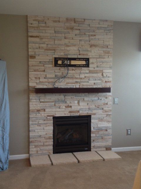 A living room with a fireplace and a brick wall