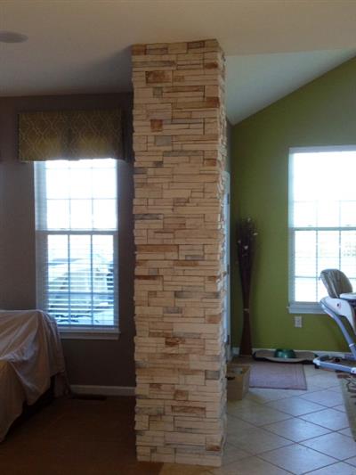 A bedroom with a stone column in the middle