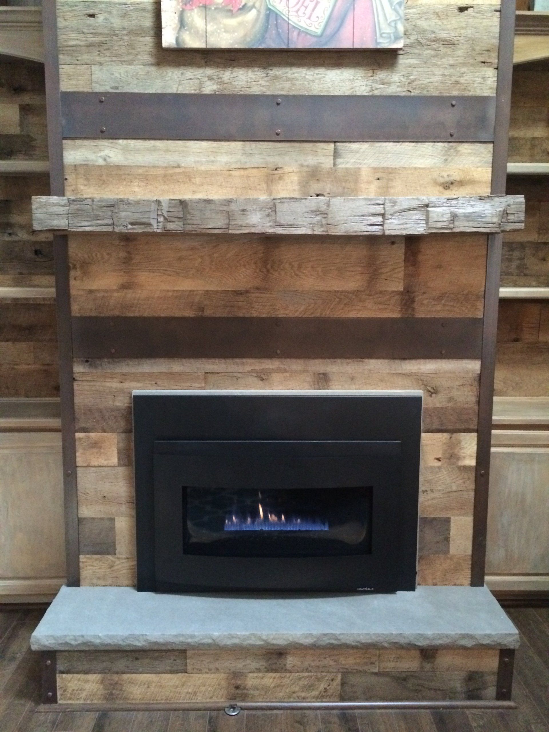 A fireplace with a painting on the wall above it