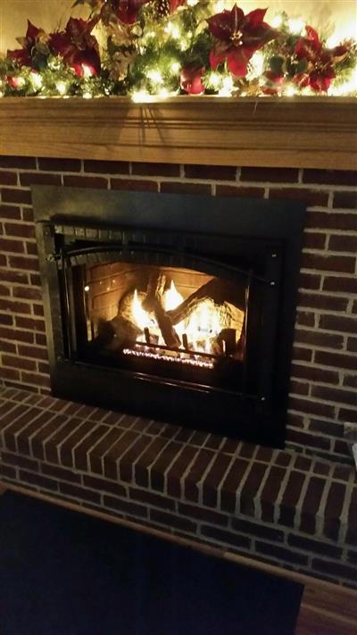 A brick fireplace with a mantle decorated for christmas.