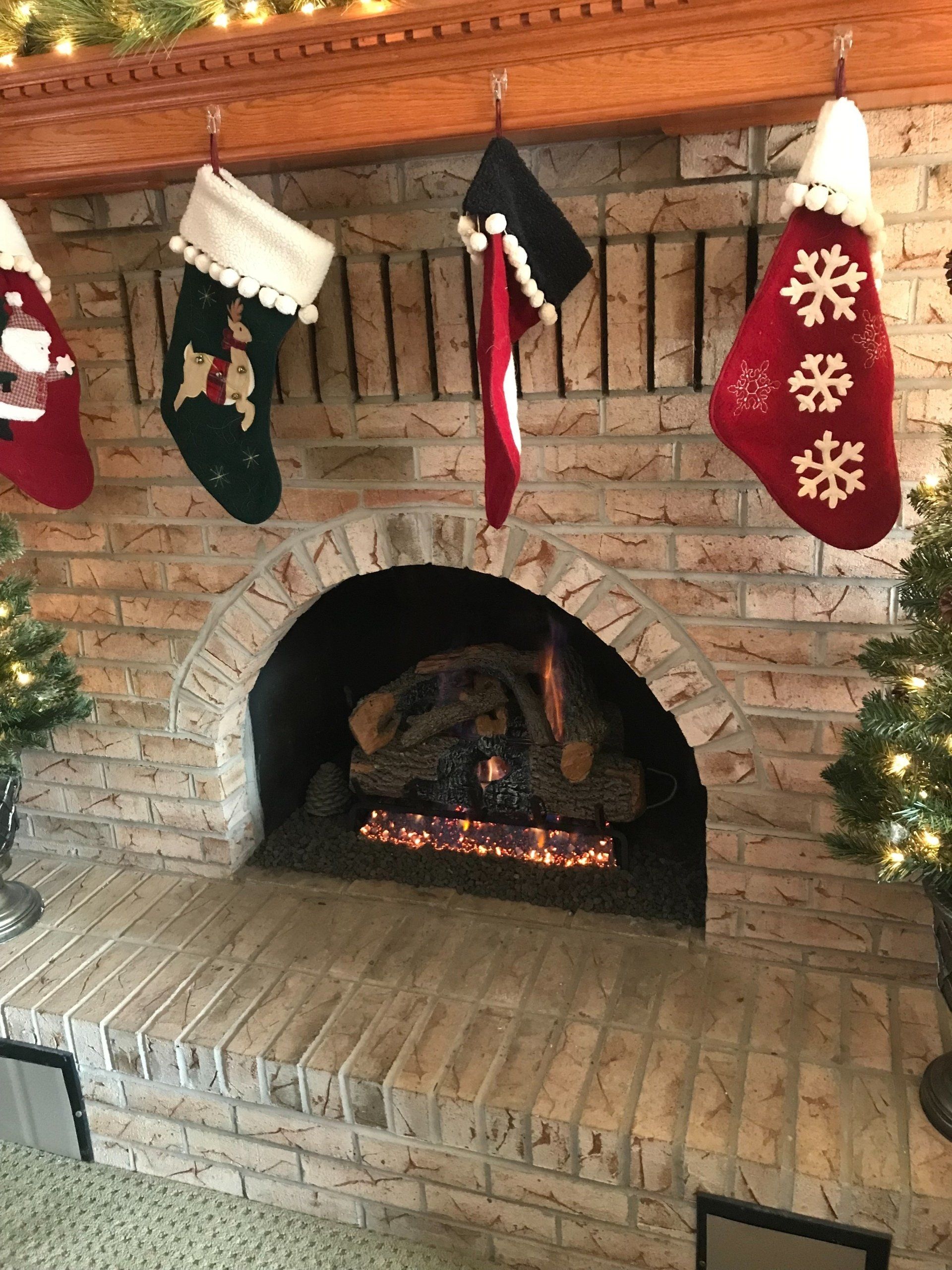 A fireplace with christmas stockings hanging from it