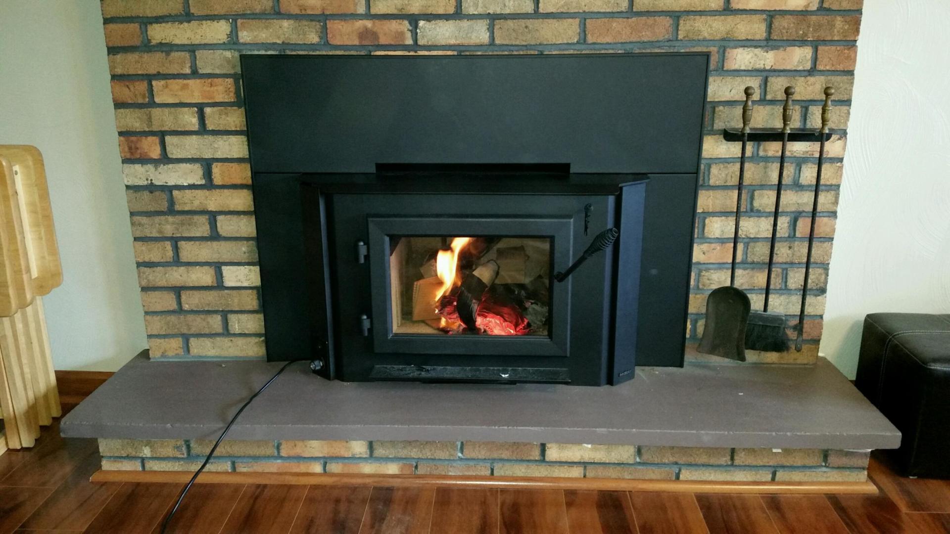 A brick fireplace with a wood stove in it