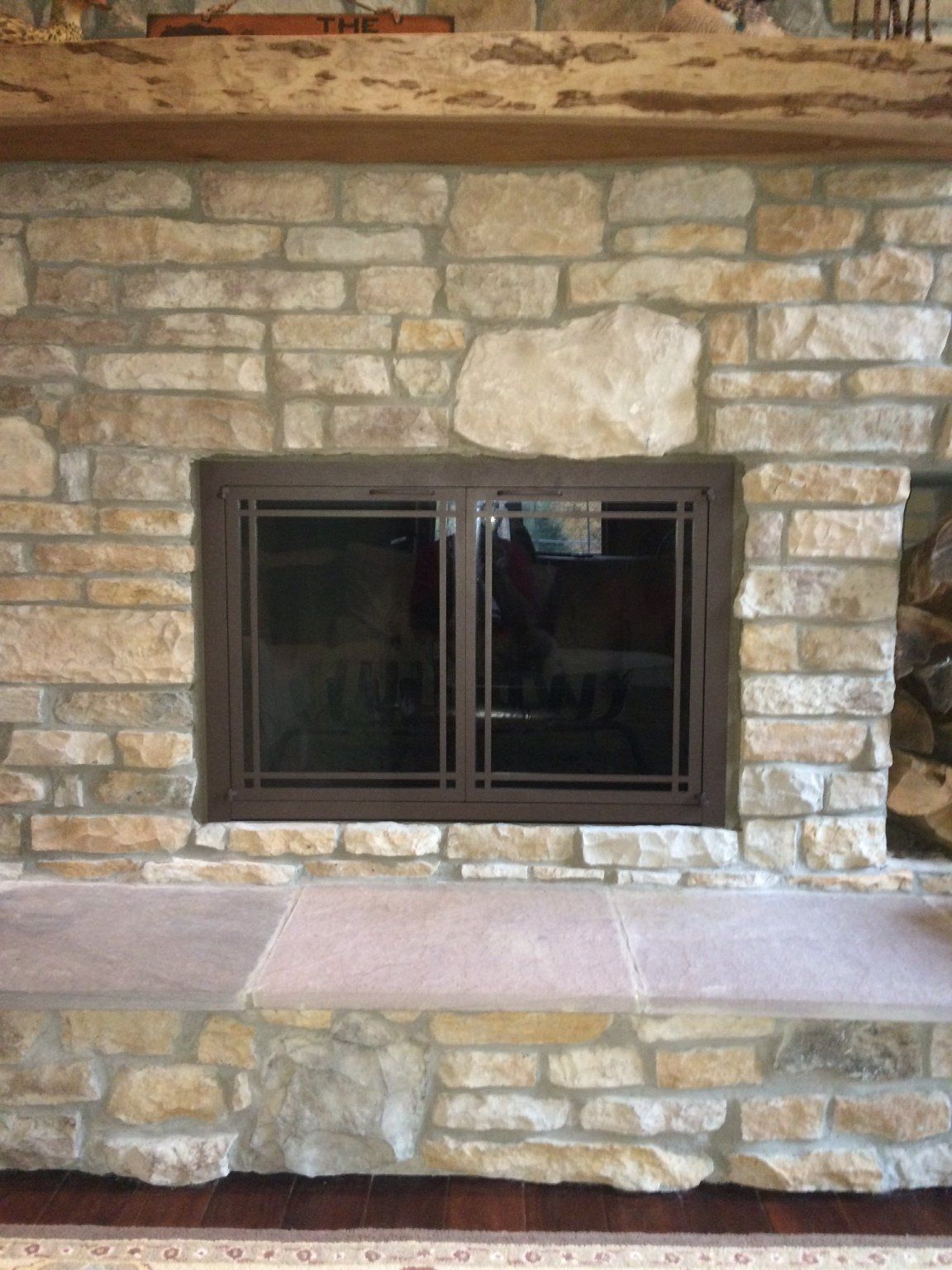 A stone fireplace with a window in the middle of it