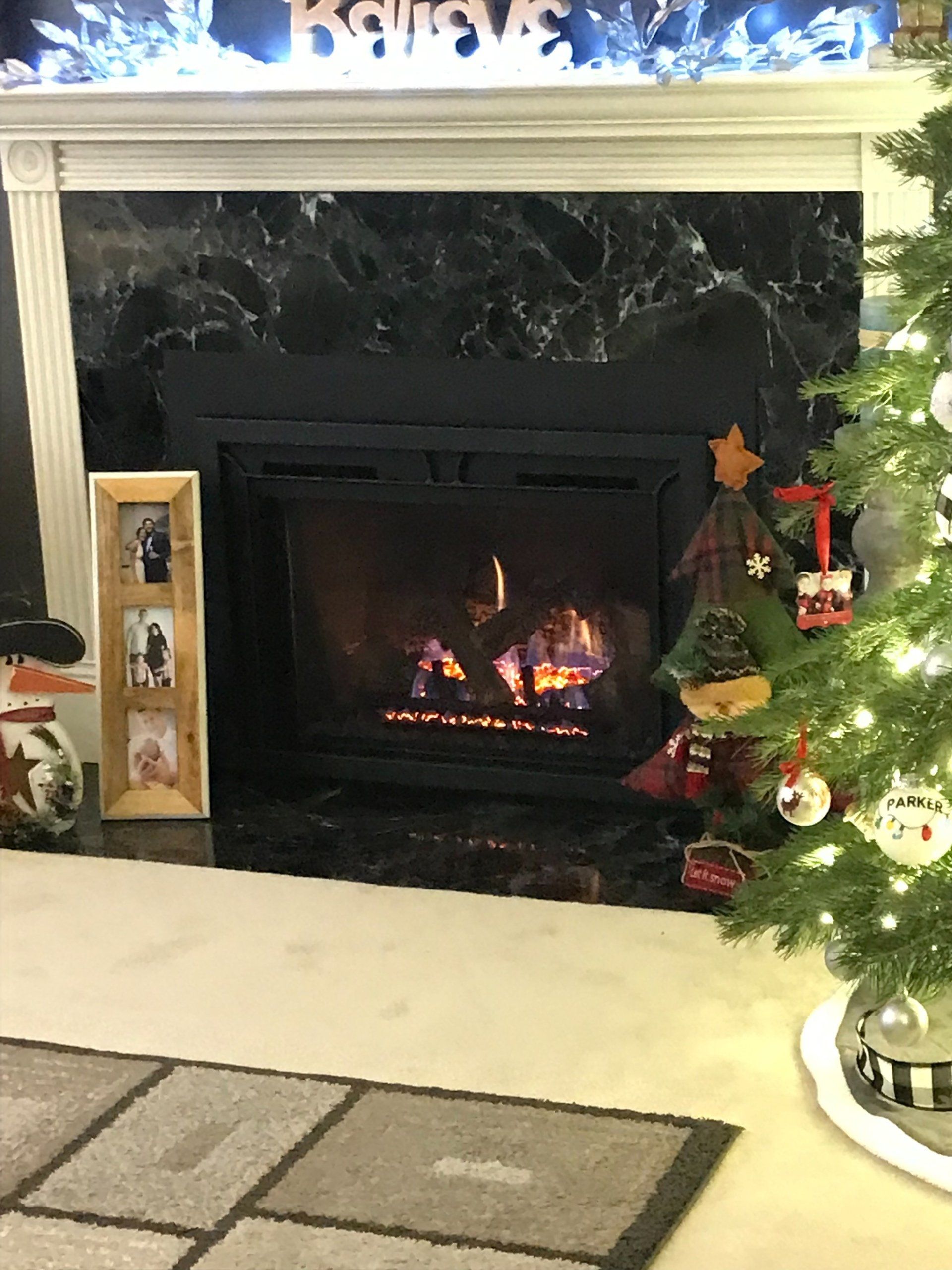 A living room with a fireplace and a christmas tree