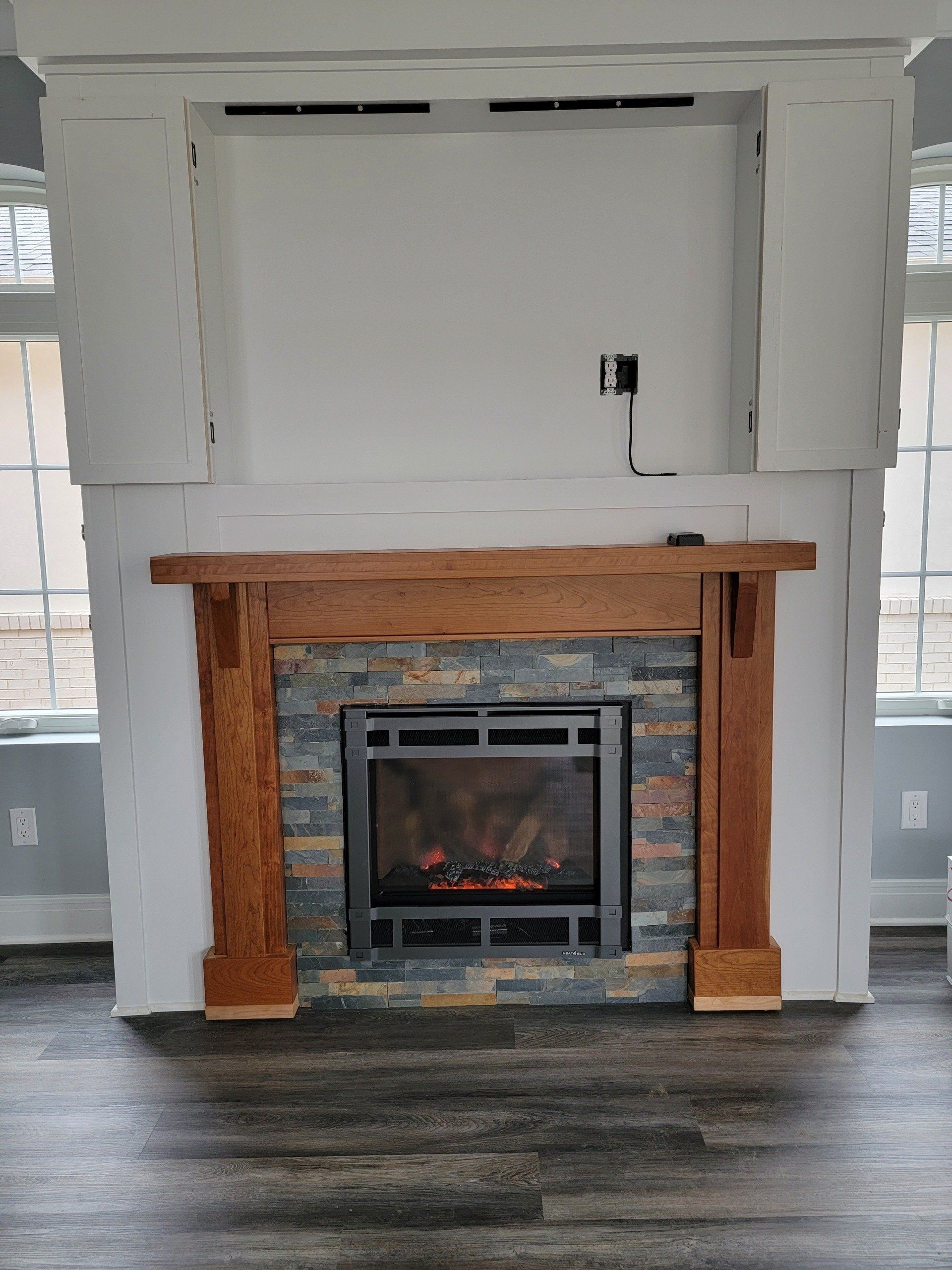 A fireplace with a wooden mantle in a living room