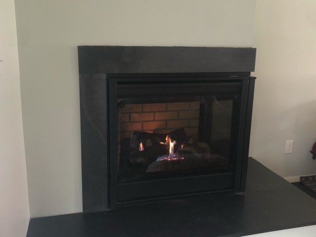 A fireplace is lit up in a living room