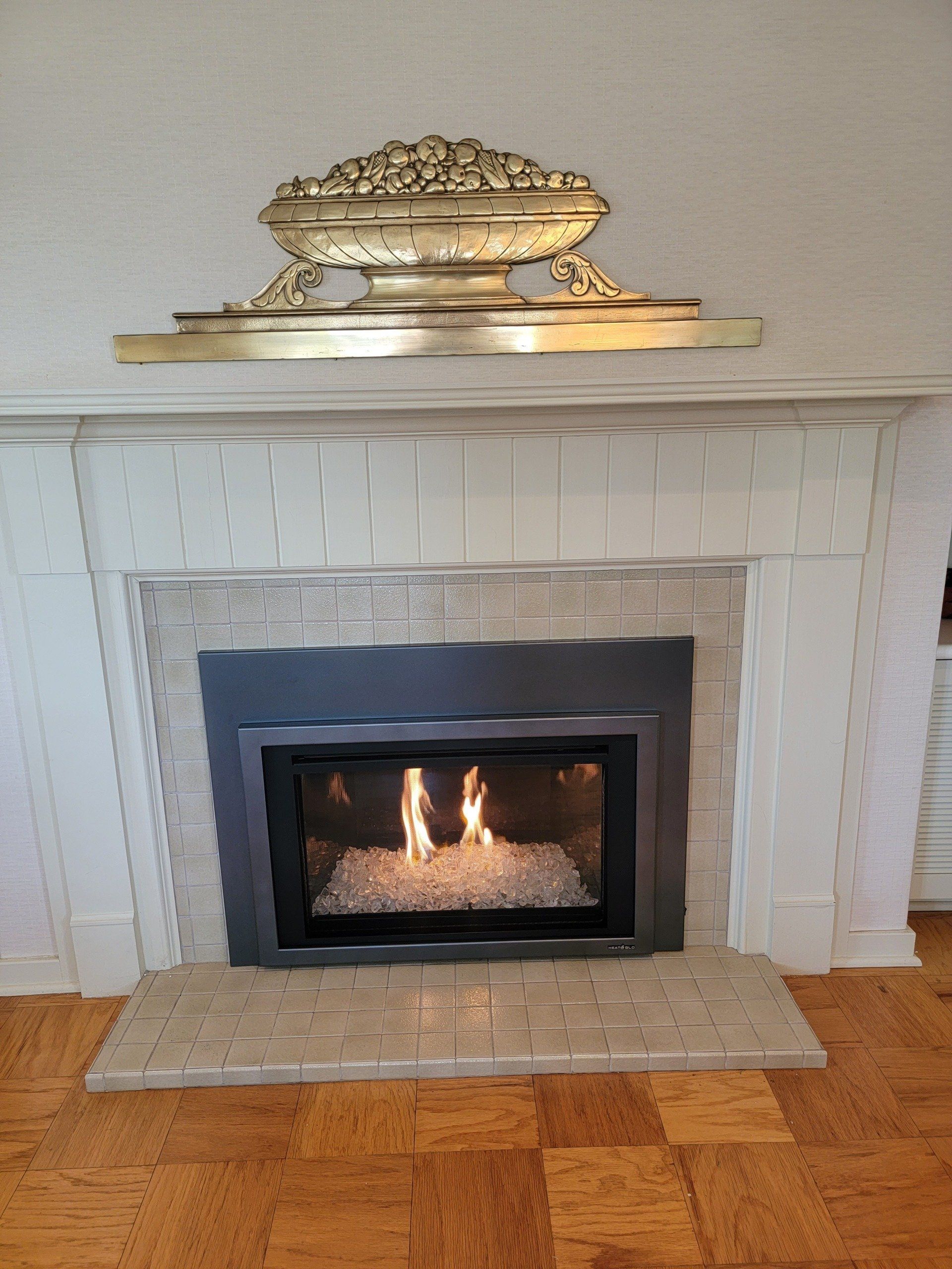 A fireplace with a vase on top of it in a living room.