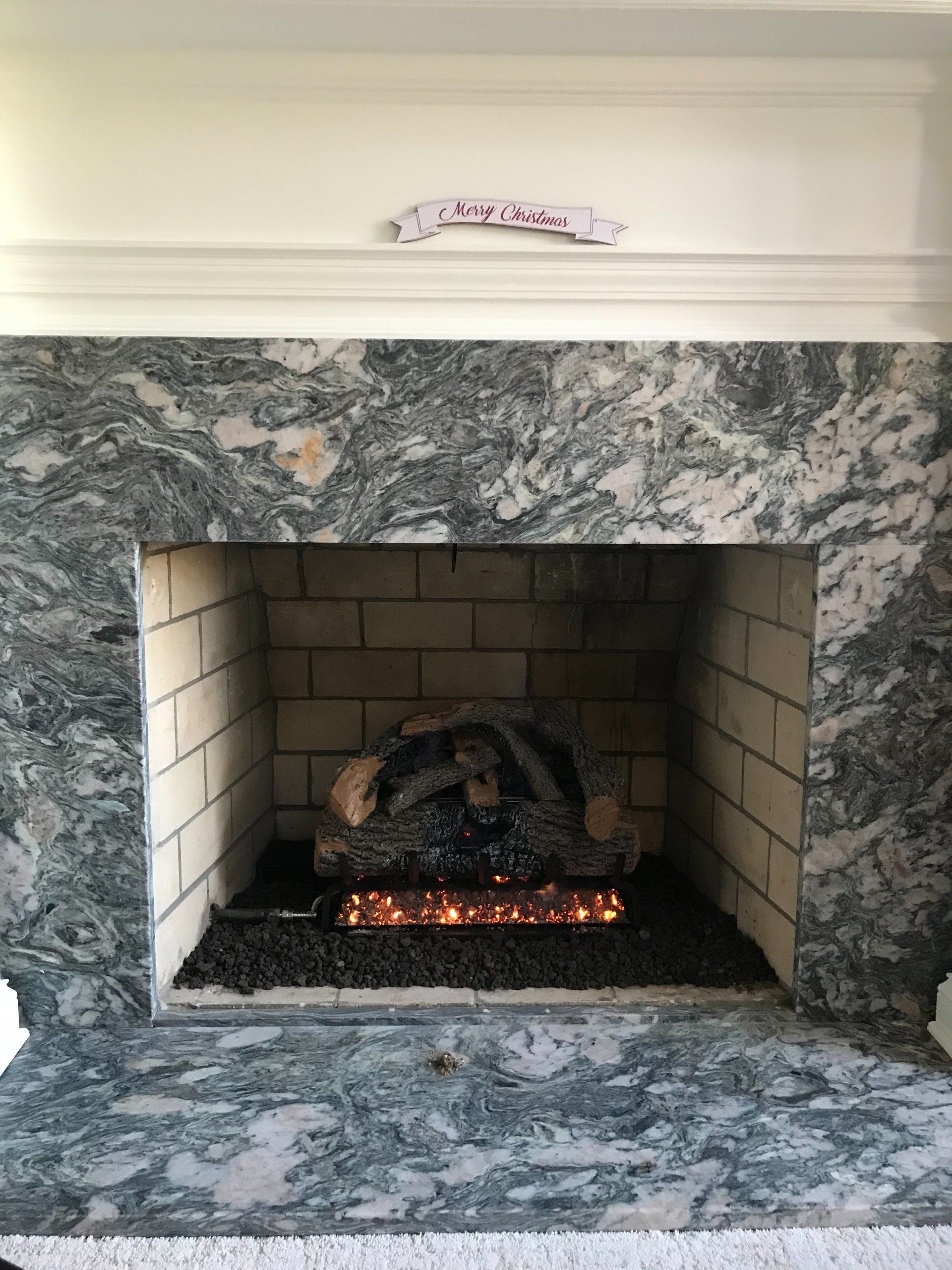 A fireplace with a marble mantle and a log in it