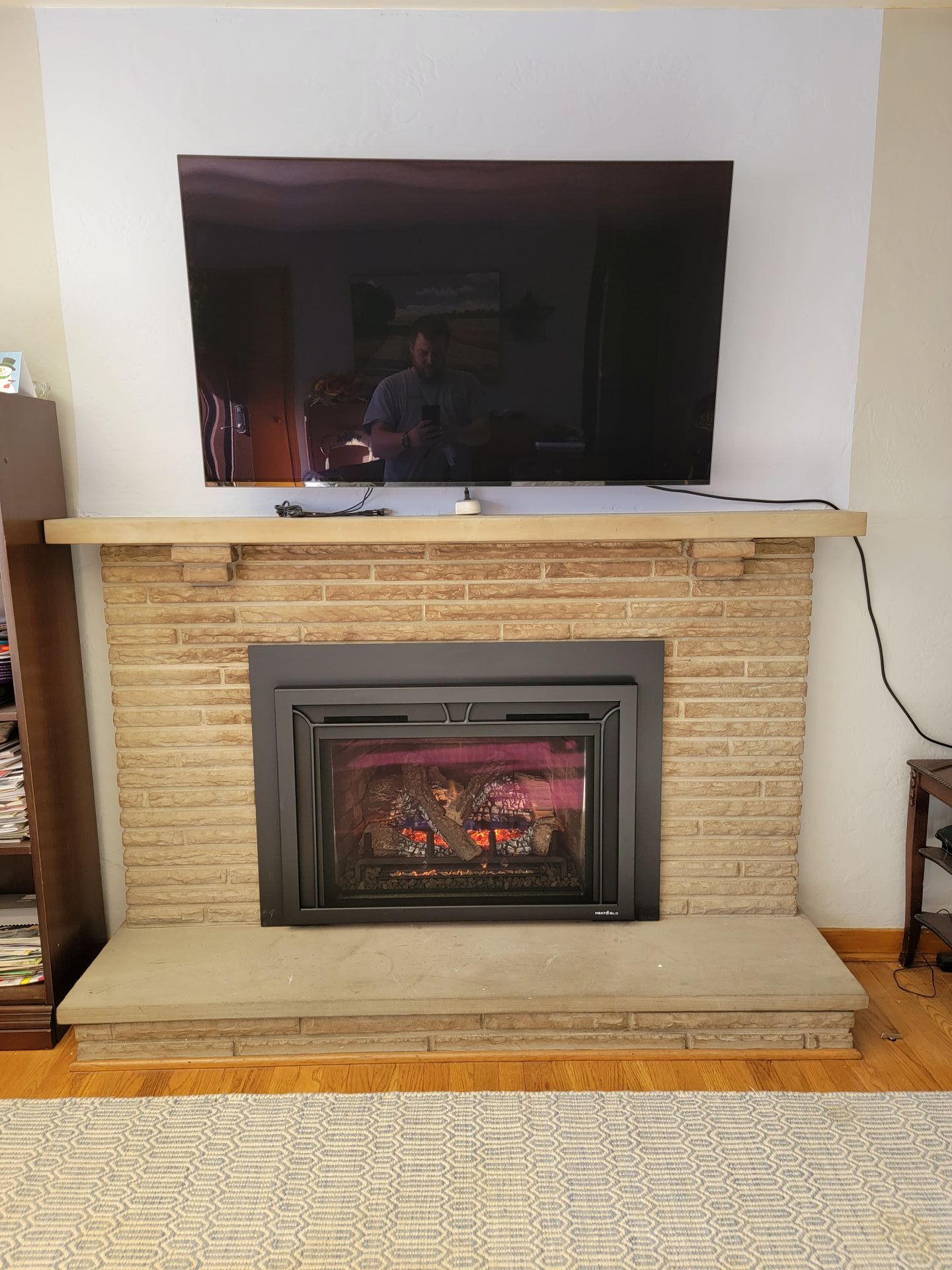 A living room with a fireplace and a flat screen tv.