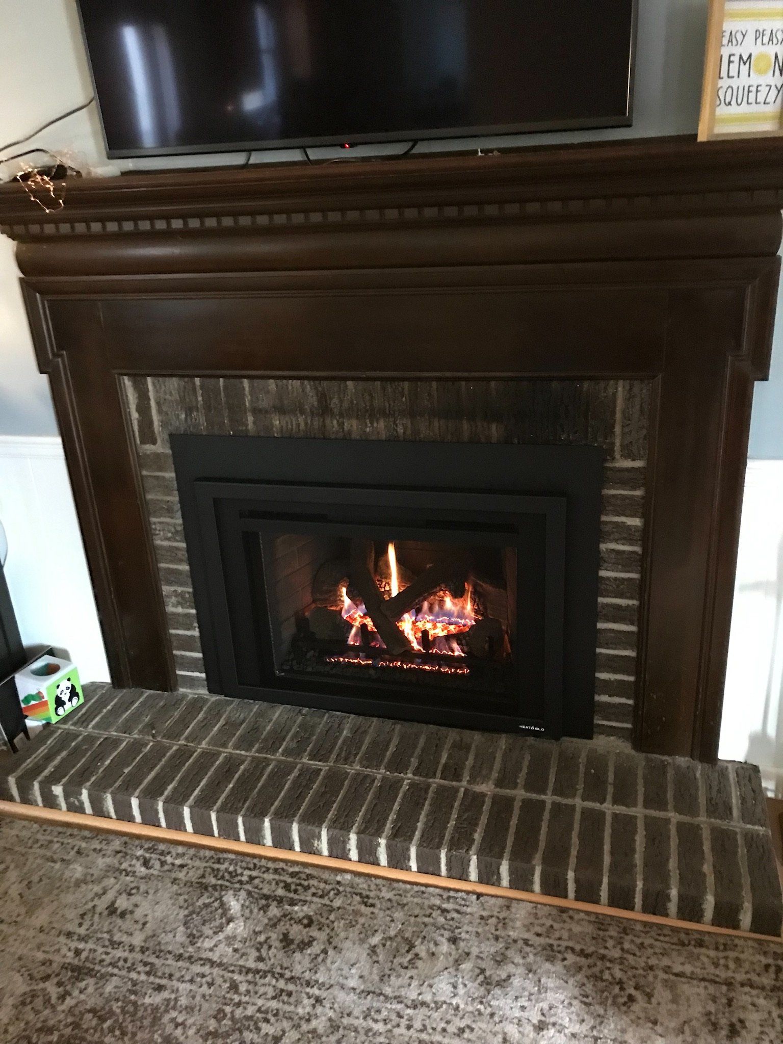 A living room with a fireplace and a flat screen tv.