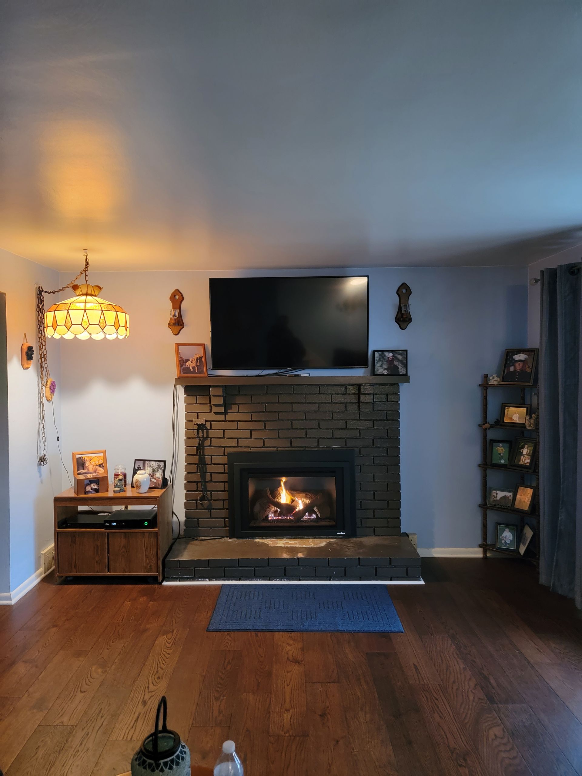 A living room with a fireplace and a flat screen tv