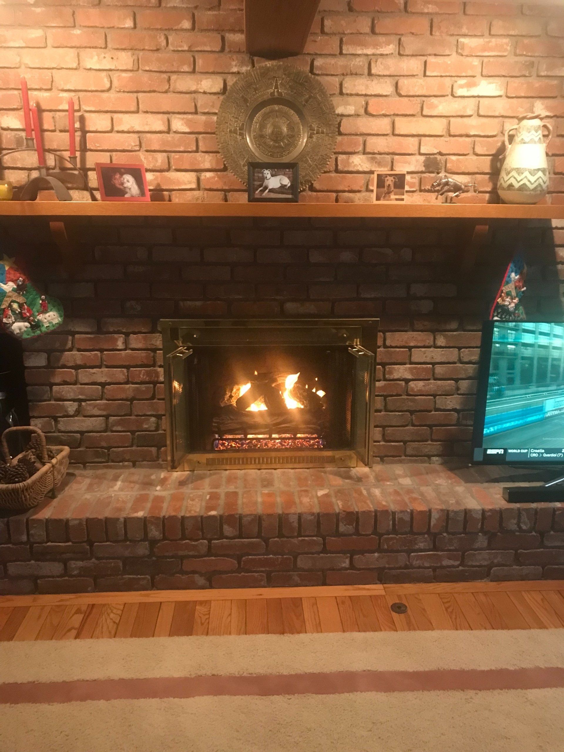 A living room with a fireplace and a television.
