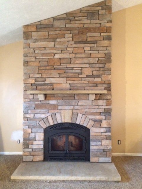 A large stone fireplace in an empty room
