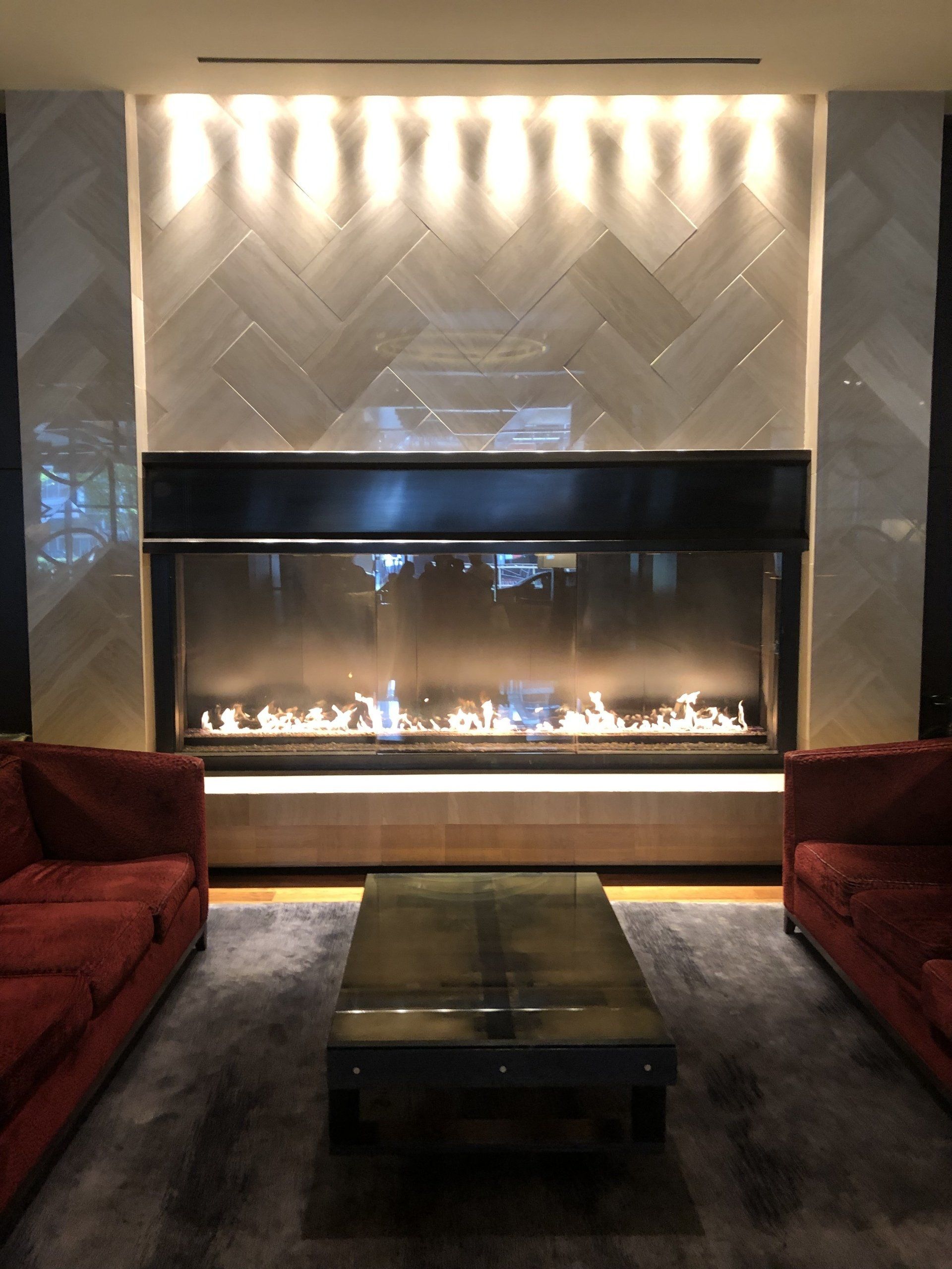 A living room with red couches and a fireplace