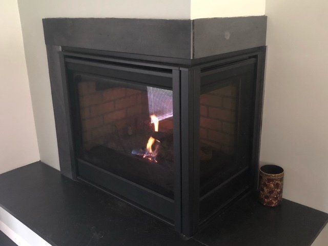 A fireplace with a brick wall and a glass door