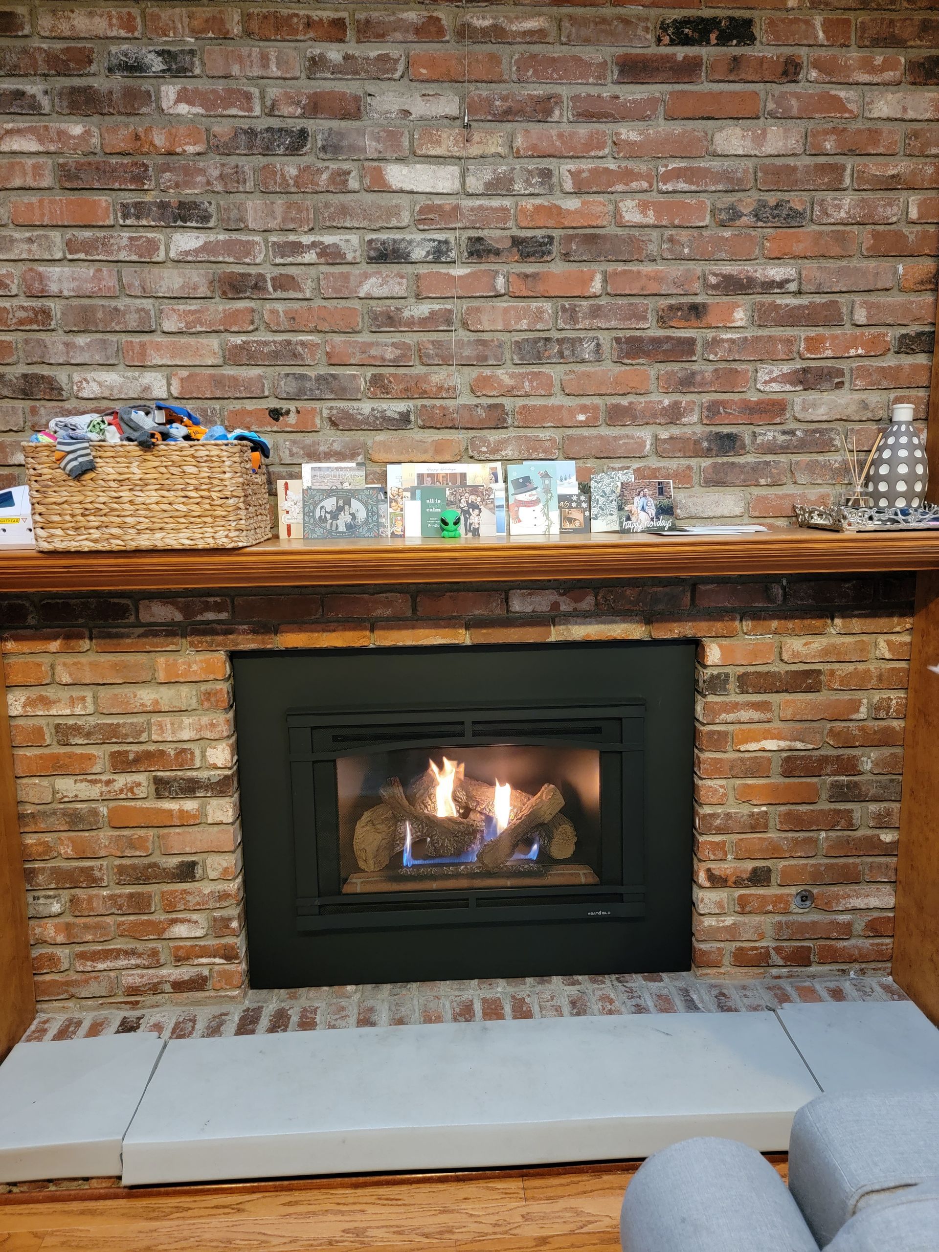 A living room with a fireplace and a brick wall.