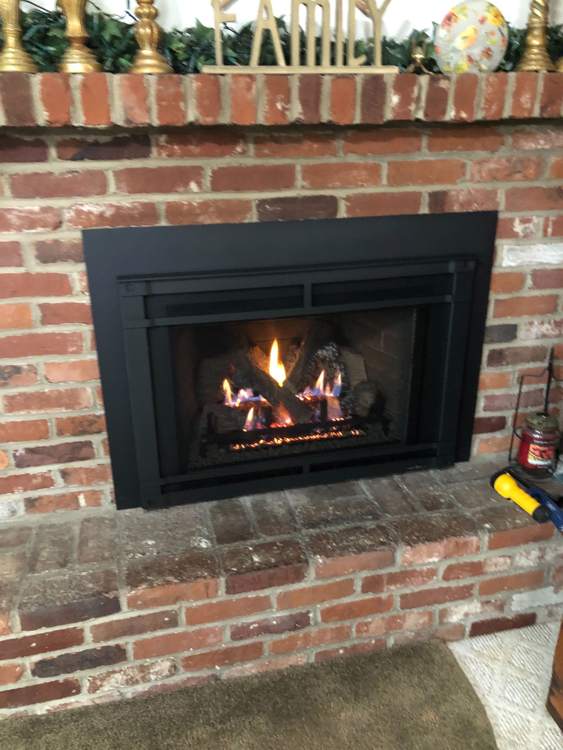 A fireplace in a living room with a sign above it that says family