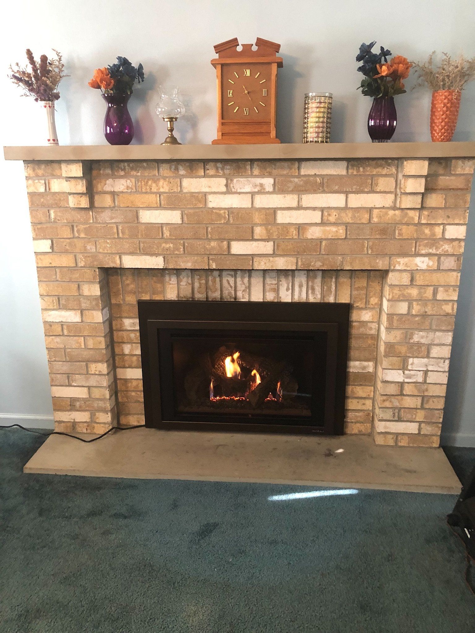 A brick fireplace with a clock on top of it